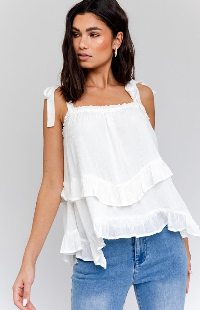 Make your look as cute as you are with the Olivia White Tie-Strap Ruffled Top! This frilly top has woven fabric straps that tie at the shoulders and are easily adjustable. Crinkle-woven fabric shapes the contrasting elasticized neckline and loose fitted tiered bodice before ending at the ruffled hem. Partially lined at the bust.