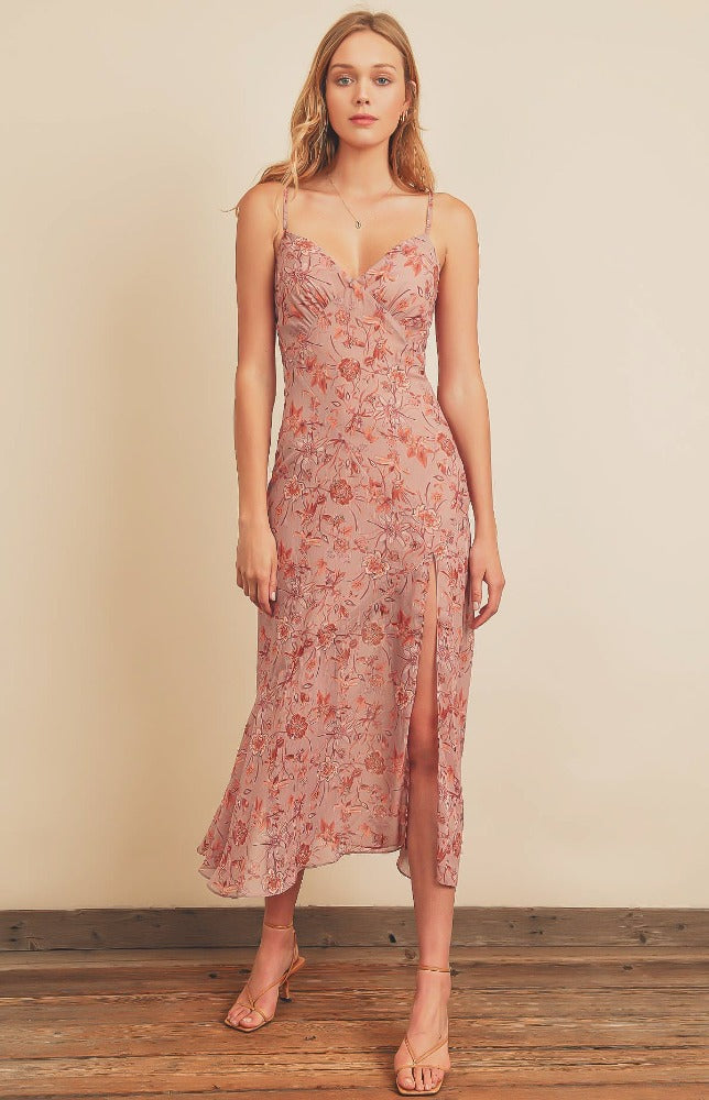 The Sweet Caroline floral print midi slip dress features a plunging neckline, diagonal seam, flared hem, thigh high front slit and tying sash at back. This dress is fully lined and comes with a hidden side zipper closure and adjustable shoulder straps. 