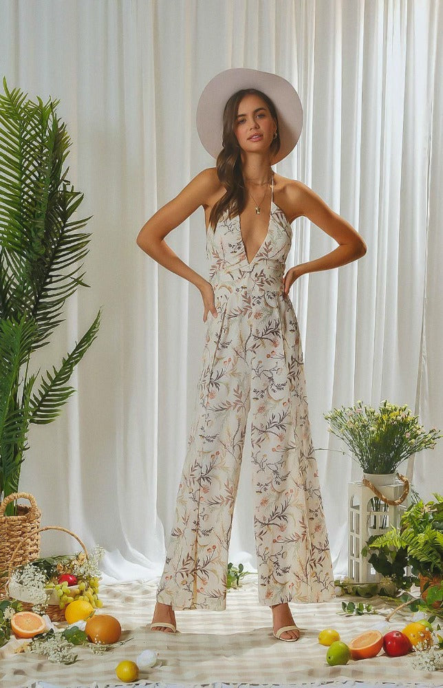 Let the breeze take you away in this floral printed halter neck jumpsuit. This lovely jumpsuit has adjustable ties at the neck and mid-back allowing you to tighten to your comfort. The low cut V-neckline leads to a fitted bodice and casual wide leg pants.