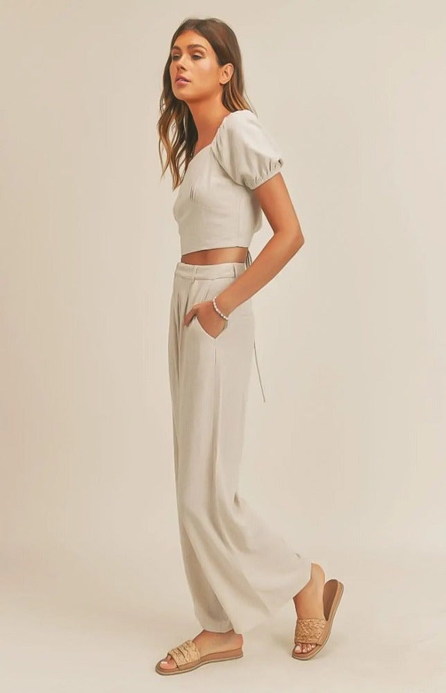 The Emery set has a delicate and airy feel. The top's lace-up back detail will make a statement as you work any room. The matching wide leg pant pair well with the top making for a very tailored look. Wear this fit during your daily errand runs with a flat  mule for a fun and causal look; or spice her up with a nude or clear heel for the evening.  