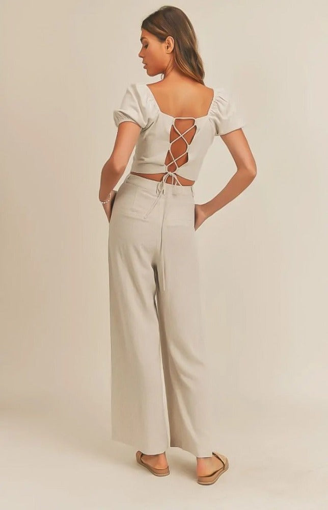 The Emery set has a delicate and airy feel. The top's lace-up back detail will make a statement as you work any room. The matching wide leg pant pair well with the top making for a very tailored look. Wear this fit during your daily errand runs with a flat  mule for a fun and causal look; or spice her up with a nude or clear heel for the evening.  