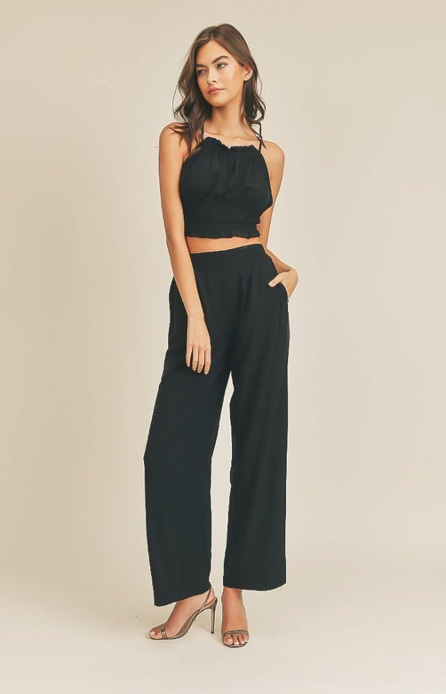 Take it easy in the Remi Halter Crop Top and Palazzo Pants Set in Black! Woven fabric shapes this sleek and casual set that includes a ruched-detail crop top with a halter neckline, and lace-up back. Matching high-waisted Palazzo pants have wide, tulip pant legs and side pockets.