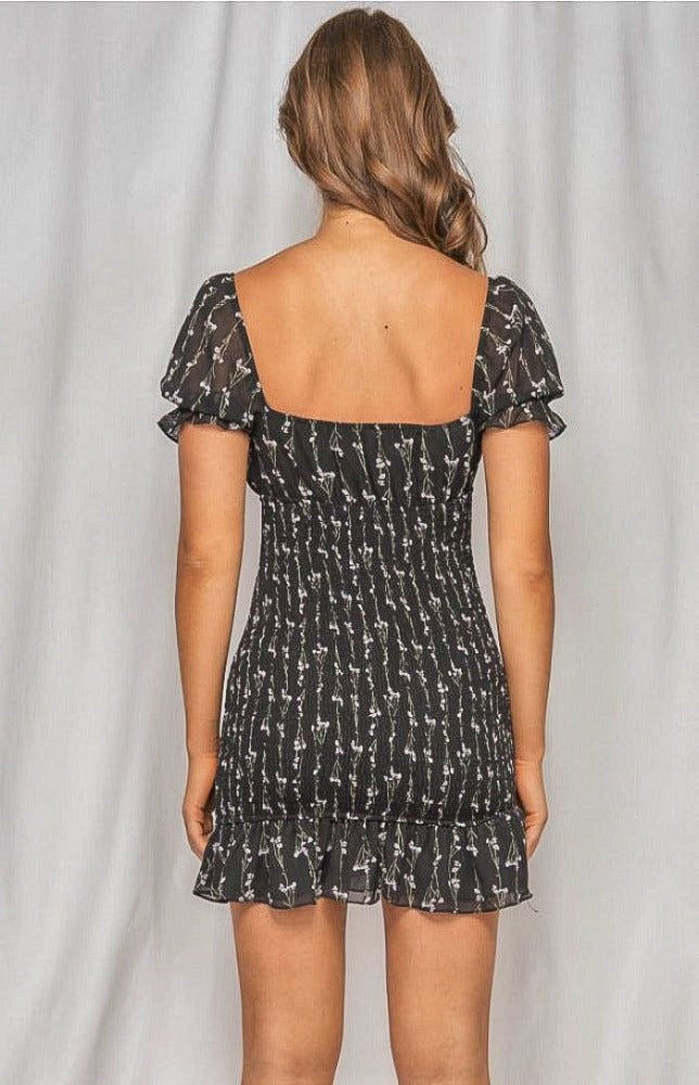 The Zoe Dainty Floral Shirred Dress in black will have you imbued romance. The delicate floral print highlights the details from the puff sleeves with ruffled arm band to the sweetheart neckline. The shirred bodice leads to a fun and flirty loose ruffle hem. This effortless, lightweight piece can go from day to night, city to beach.