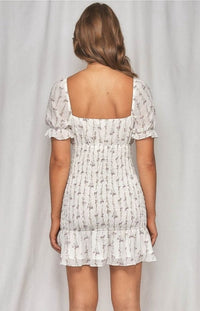 The Zoe Dainty Floral Shirred Dress in white will have you imbued romance. The delicate floral print highlights the details from the puff sleeves with ruffled arm band to the sweetheart neckline. The shirred bodice leads to a fun and flirty loose ruffle hem. This effortless, lightweight piece can go from day to night, city to beach.