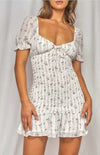The Zoe Dainty Floral Shirred Dress in white will have you imbued romance. The delicate floral print highlights the details from the puff sleeves with ruffled arm band to the sweetheart neckline. The shirred bodice leads to a fun and flirty loose ruffle hem. This effortless, lightweight piece can go from day to night, city to beach.