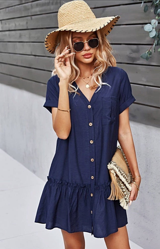 The Sophia Navy Blue Button-Up Mini Dress is what daydreams are made of! Light and breezy fabric creates this perfect sundress with cuffed arm sleeves, a V-neckline, and a cute ruffled hem. Delicate buttons add a darling detail as they travel down the front to an A-line mini skirt with a high, loose waist and seamed, ruffle hem.