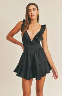 Don't be surprised if secret admirers make themselves known when you step out in the Anastasia V-Neck Satin Ruffle Playsuit! Romantic black satin comes together to form a deep ruffled V-neckline and fitted bodice. A sexy lace up detail delicately crosses the back, finishing with tailored shorts that end with ruffled hems. 